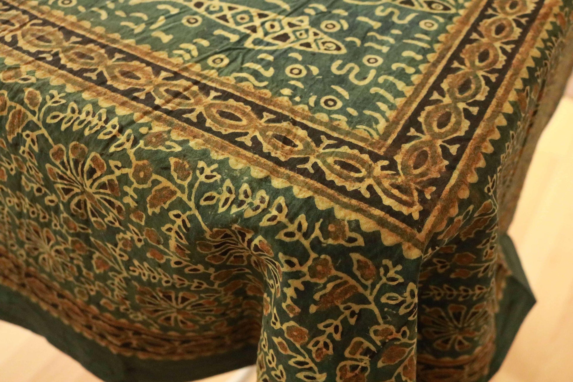 Green and saffron hand-dyed block print table cover with 8 matching napkins showcasing fish and floral patterns - an eco-friendly and ethically made dining ensemble by Ethimaart.