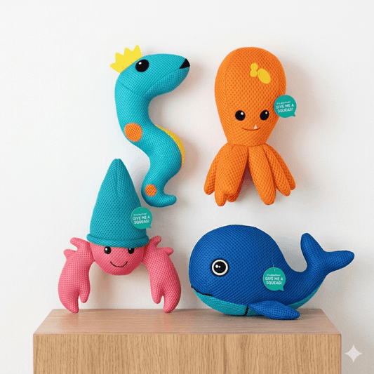 Four colorful plush toys shaped like a snake, octopus, crab, and whale on a wooden stand with a white background. Knitted Interactive Plush