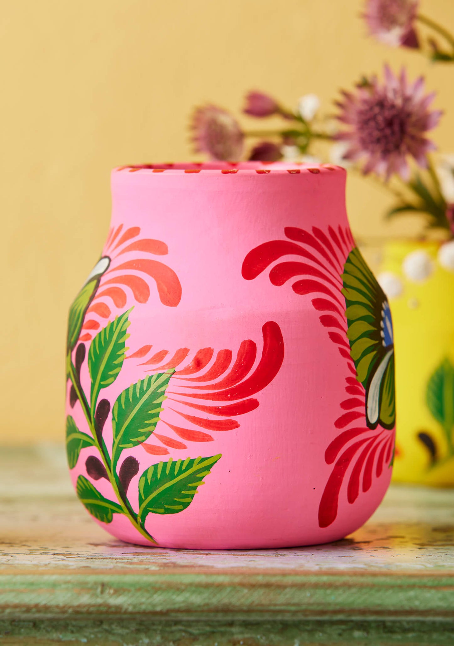 Artisan-made pink botanical clay vessel for modern home shelf decor.