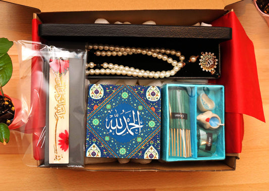 Find serenity this Ramadan with a gift box featuring a shell pearl tasbeeh, pressed flower resin bookmark, glittering "Alhamdulillah" plaque, and calming incense set. Ethically sourced & eco-conscious. Perfect for colleagues or loved ones.