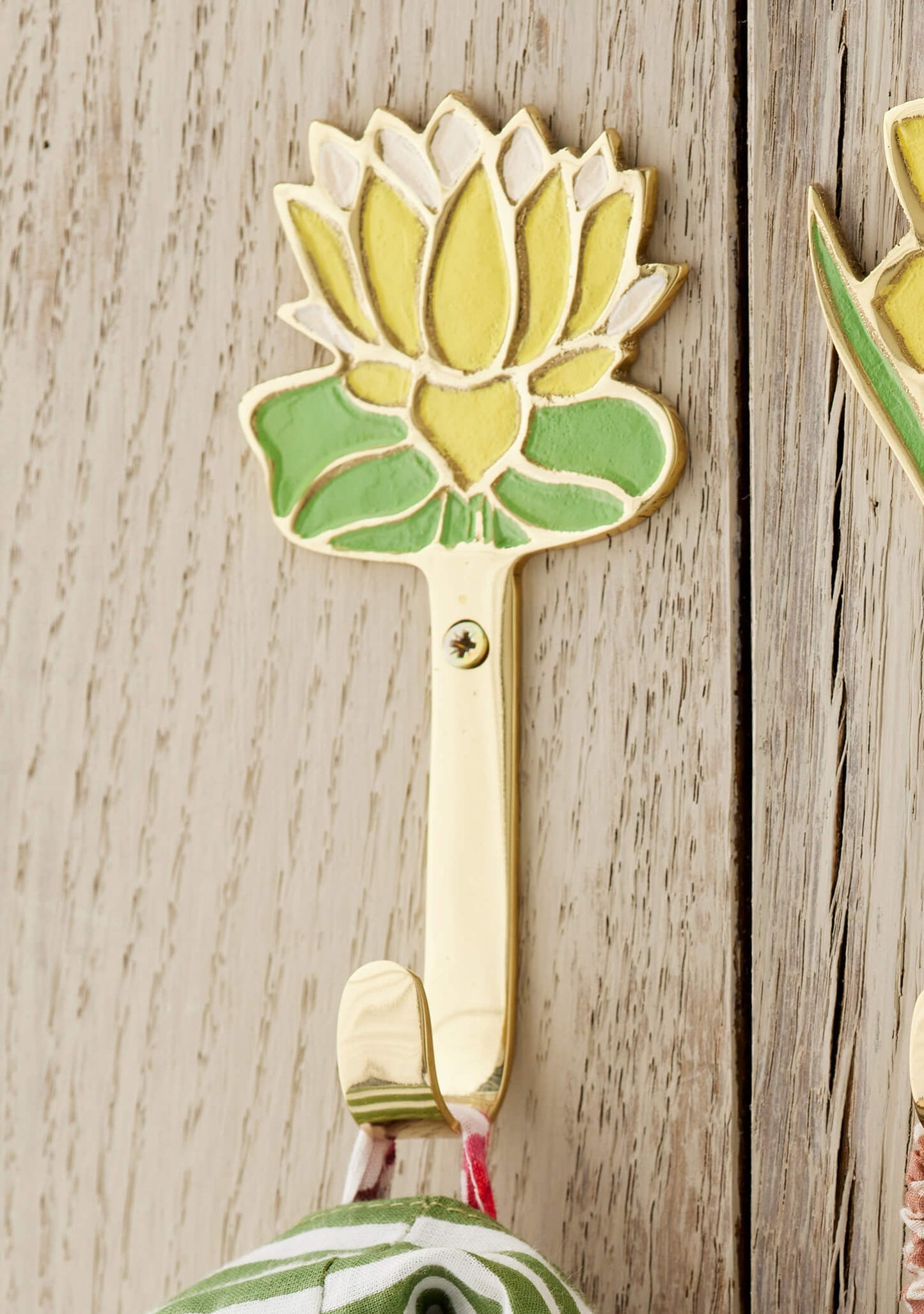 Decorative yellow flower wall hook shaped on a wooden surface