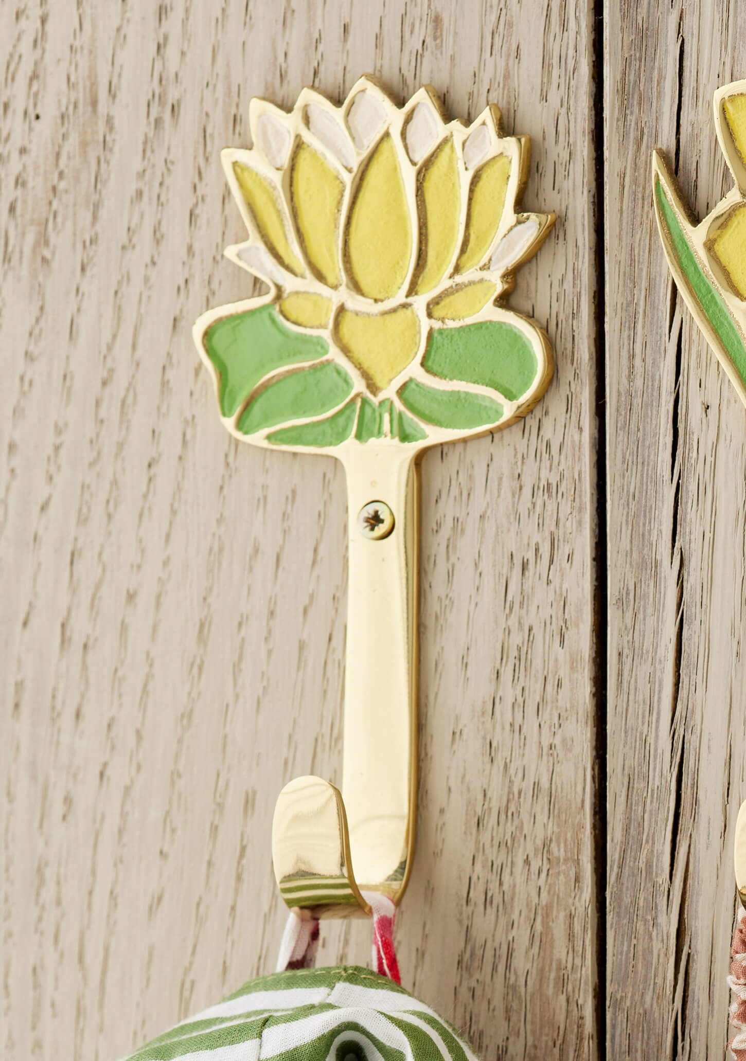 Decorative yellow flower wall hook shaped on a wooden surface